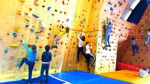 Bambini che si arrampicano su una parete di arrampicata